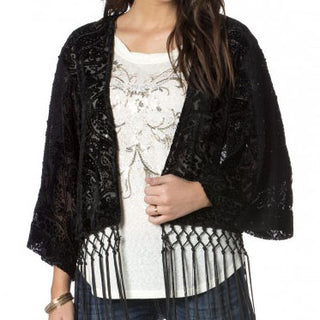 Schwarzer Spitzen-Kimono mit Samtfransen über einem weißen Shirt und bestickter Jeans.